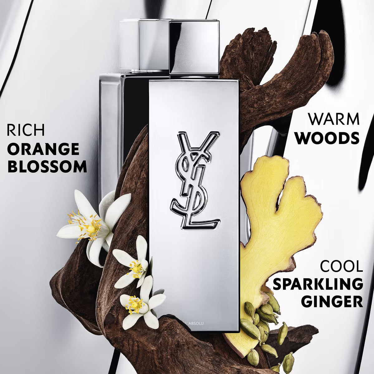YSL perfume bottle with floral and wood elements on a white background